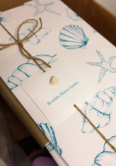 an open gift box with seashells and starfish wrapping paper on the inside