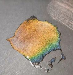 a rainbow colored substance is on the ground