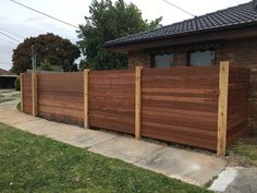 a wooden fence in front of a brick house