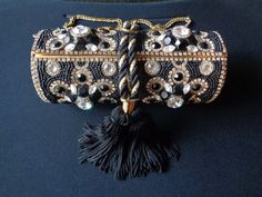 "Glamorous Handmade Artisan Vintage by M & J Hansen Designs LTD Made in USA Gold Metal Minaudiere Evening Purse Clutch Mini Bag Bejeweled With Black Glass Beads Clear Rhinestones & Fringe Black Tassel With Gold Tone Chain Strap This is an absolutely beautiful and glamorous evening purse/shoulder bag by M & J Hansen Designs LTD Made in USA. The purse is cylinder in shape and is covered with beautiful black glass beads beading. It is then accented with clear rhinestones crystal or glas Luxury Black Beaded Evening Bag, Black Embellished Evening Bag, Black Beaded Evening Bag For Wedding, Black Beaded Evening Bag As Gift, Black Beaded Evening Bag For Gift, Black Embellished Evening Bag As Gift, Black Embellished Evening Bag For Gift, Luxury Black Embellished Clutch, Black Embellished Clutch For Wedding