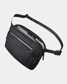 a black fanny bag with two zippers on the front and one zipped pocket