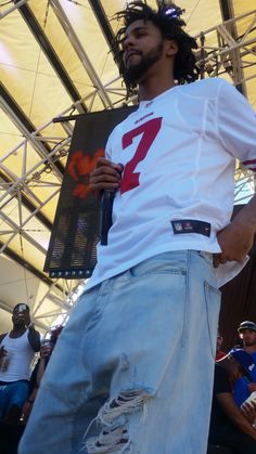 a man with dreadlocks standing in front of a crowd