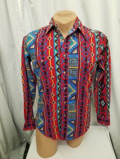 Vintage 90s Wrangler Cowboy Cut Brushpopper Rainbow Southwestern Aztec Western Button Up Thick Shirt Top w X-Long Tails.  Shirt has 7 buttons down the front, 2 front chest pockets, and sleeves have 2 buttons on the cuffs. Top is in excellent condition...see pics!  Measurements: shoulder to shoulder 17 1/2 in, chest 42 in, waist 40 in, sleeves shoulder to cuff 25, sleeves pit to cuff 23, neck to bottom length front 28 1/2, length in back 31 1/2 in. Multicolor Long Sleeve Western Shirt, Multicolor Cotton Western Shirt, Multicolor Casual Shirt For Rodeo, Multicolor Bohemian Shirt With Button Closure, Bohemian Multicolor Shirt With Button Closure, Western Style Long Sleeve Tops For Festival, Wrangler Cowboy, Wrangler Cowboy Cut, Long Tail