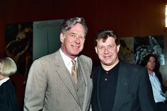 two men in suits standing next to each other