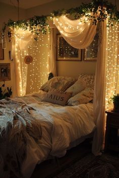 a bed covered in white lights next to a window with curtains and pillows on it