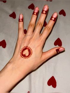 a woman's hand with a hen tattoo on it and hearts all over the bed