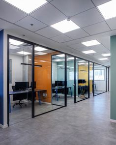 an empty office with glass walls and desks