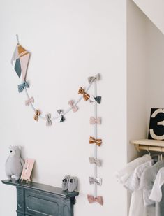 there is a wall decoration with bow ties on the clothes line and an elephant toy next to it