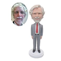 a bobble head with an older man in a suit and tie next to a white background