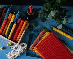 there are many different colors of thread on the table next to some scissors and needles