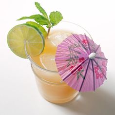 two cocktails with umbrellas and lime on the rim are sitting next to each other