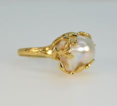 🌹 Welcome to JeansJewelryStudio! 🌹 DESCRIPTION Presented to you is a beautiful, adjustable baroque pearl ring. The pearl is natural, featuring a stunning white hue with rainbow overtones, and no treatments have been applied after harvesting. This is not just any baroque pearl; it's near flawless, boasting a beautifully smooth surface, high luster, and thick nacre. The ring is adjustable, making it suitable for most sizes. This is truly artisan jewelry with a unique and stylish design. Metal: Gold Vermeil, 18K gold over 925 solid sterling silver Size of the ring: Adjustable, fit for most sizes Pearl: 19 x 15 x 12 mm Please refer to the pictures for the color and shape of the pearl. You will receive exactly what you see in the pictures. Pearls are a timeless classic and have been in existe Luxury Heirloom Oval Pearl Ring, Ring For Girls Gold, 14k Gold Hallmarked Pearl Ring, Luxury Handmade Yellow Gold Pearl Ring, White Baroque Pearl Ring With Pearl Drop, Gold Baroque Pearl Ring, Elegant Baroque Pearl Open Ring, Elegant Gold Baroque Pearl Ring, Luxury Adjustable Gold Pearl Ring