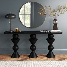 a living room with a round mirror and black table in it's centerpiece