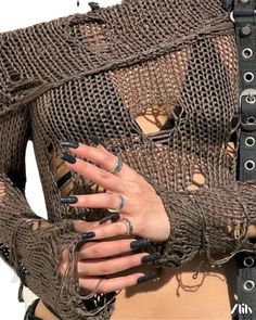 a close up of a person wearing rings and holding their hands in front of her chest