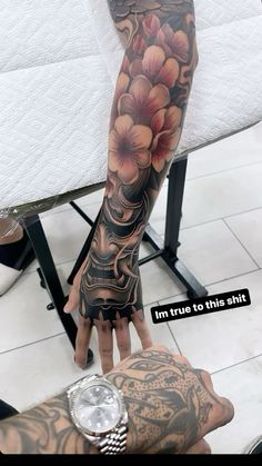 a man with tattoos on his arm and hand