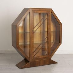 a wooden display case sitting on top of a hard wood floor next to a white wall