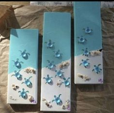 three blue boxes with sea shells and seashells on them sitting on a piece of paper