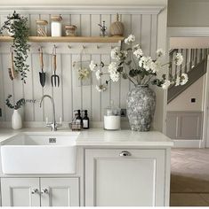 a kitchen with white cabinets and flowers on the counter