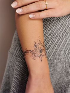 a woman's arm with a flower tattoo on the left side of her arm