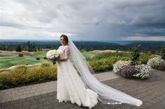 a woman in a wedding dress holding a bouquet and standing next to a golf course