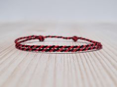 Simple black and red string bracelet, made from a nylon cord.  The bracelet has an adjustable size thanks to the sliding knot. This a simple fabric jewelry that can be worn alone or stacked with other bracelets. Suitable for both men and women. The bracelet is fully water-resistant, so you can swim and shower with it. - - - - - - - - - - Materials: Nylon cord - Color: Black and red - The cord twisted by hands - - - - - - - - - Adjustable size - Open from 15cm (5.9") to 25cm (9.8"). - - - - - - - Minimalist Red Adjustable Braided Bracelets, Red Adjustable Minimalist Braided Bracelets, Red Adjustable Braided Waxed Cord Bracelets, Minimalist Adjustable Red Braided Bracelet, Adjustable Red Braided Nylon Cord Bracelet, Adjustable Red Braided Nylon Bracelet, Adjustable Red Nylon Cord Bracelet, Adjustable Red Nylon Cord Braided Bracelet, Casual Red Braided Waxed Cord Bracelets