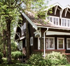 a brown and white house in the woods