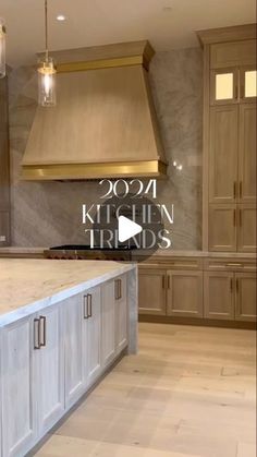 a kitchen with marble counter tops and wooden cabinets in the background is an image of a gold range hood