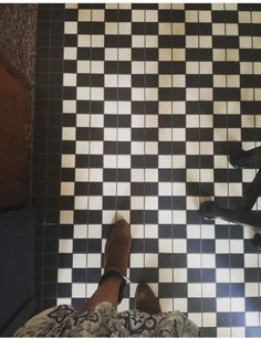 a person standing on a black and white checkered floor