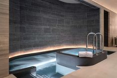 an indoor jacuzzi is shown in the middle of a room with stone walls and flooring