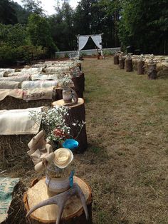 there are many logs that have been placed in the grass with flowers and stuffed animals on them