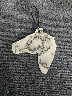 a white marble ornament hanging on a black cord