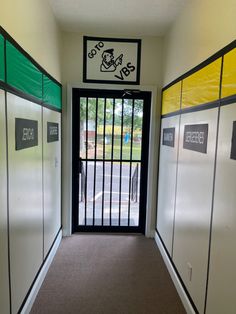 an empty hallway with several doors and signs on the side walk leading to a parking lot