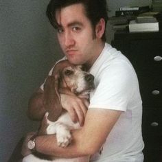 a man holding a dog in his arms