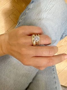 a woman's hand with a gold ring and two diamond rings on her fingers