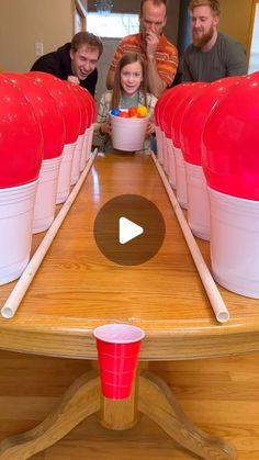 a group of people sitting around a table with bowls and cups on top of it