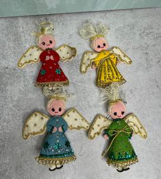 three christmas angel ornaments are sitting on a table