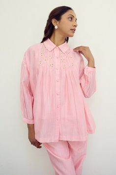 Pink shirt featuring smocked detailing with hand embroidered flower detail and scalloped collar. - Aza Fashions Cotton Tops With Embroidered Cuffs For Work, Cotton Top With Embroidered Cuffs For Work, Cotton Tops With Pintucks And Relaxed Fit, Relaxed Fit Cotton Tops With Pintucks, Spring Collared Tops With Gathered Sleeves, Cotton Long Sleeve Tops With Pintucks, Long Sleeve Cotton Tops With Pintucks, Embroidered Tops With Relaxed Fit, Cotton Smock Tops For Workwear