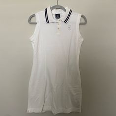 a white polo shirt hanging on a hanger