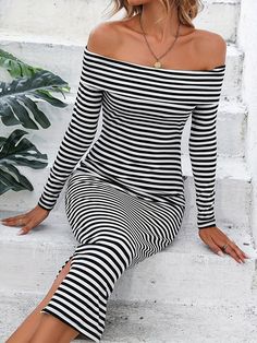 a woman is sitting on the steps wearing black and white striped clothing with her legs crossed