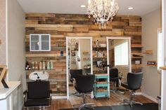 a salon room with chairs, lights and shelves on the wall that have wooden planks