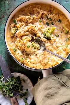 a pot filled with macaroni and cheese on top of a green tablecloth