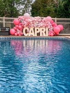 a pool with some balloons on it and a sign that says capri in the middle