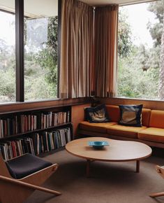 a living room filled with furniture and lots of bookshelves next to a window