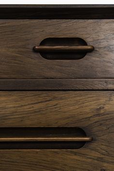 a close up view of the handles on a wooden dresser drawer with dark wood grained finish