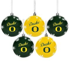 four green and yellow ornament ornaments with the letter o on them, each decorated with snowflakes