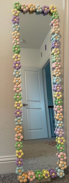 a mirror that has some kind of candy bead around it and is sitting on the floor