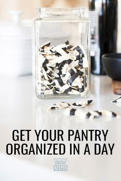 a glass jar filled with black and white confetti on top of a counter