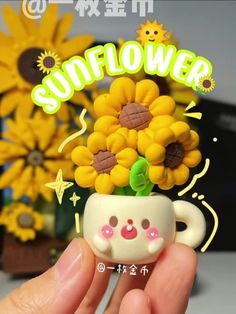 a hand holding a small cup with sunflowers in it's center and the word hello kitty on top