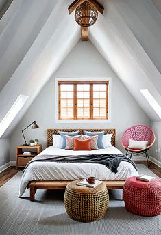 an attic bedroom with white walls and vaulted ceilings, two wicker stools on either side of the bed