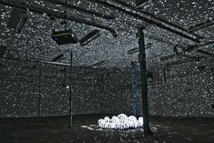 an empty room with rain falling on the floor and lights in the ceiling above it